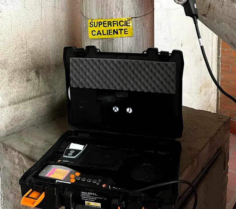 Analizador de gases Testo en su maletín junto a una superficie caliente