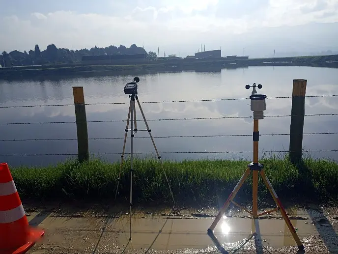 Sonómetro y estación meteorológica midiendo emisión de ruido junto a un lago